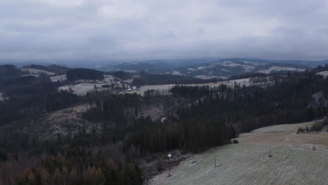 Volando-Sobre-El-Paisaje-Sobre-Los-árboles-Y-La-Vista-Del-Pueblo-Circundante-Durante-El-Comienzo-De-Las-Nevadas