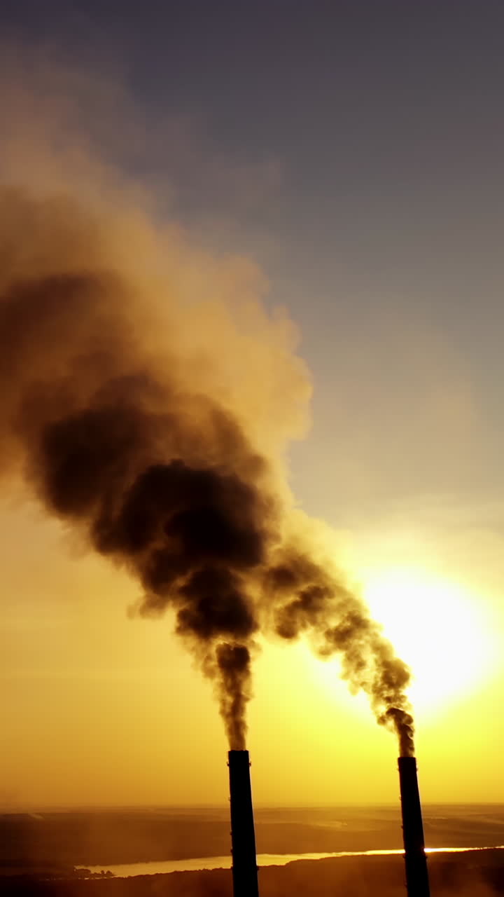 Smoking pipes of factory. Industrial chimneys with heavy smoke causing air pollution problem Vertical video