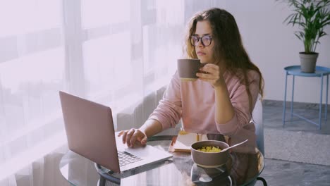 la dama desayuna en una mesa pequeña en una mañana soleada.