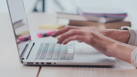 perfil cerca de las manos de la mujer escribiendo en la computadora portátil en la luz mesa de trabajo moderno