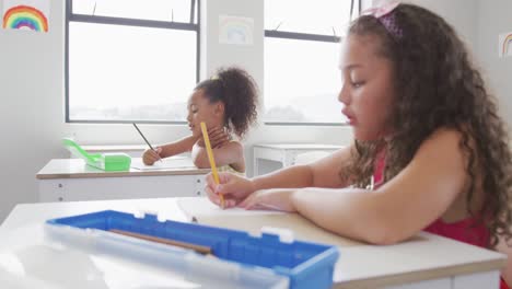 Video-of-biracial-girls-sitting-at-school-desks-and-learning