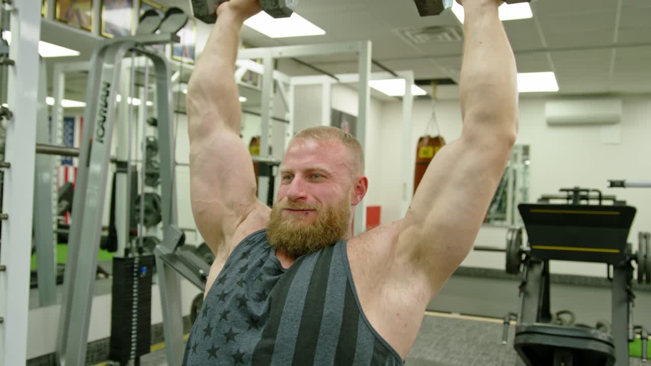 Bodybuilder muscoloso che solleva pesi. Persona atletica che si impegna