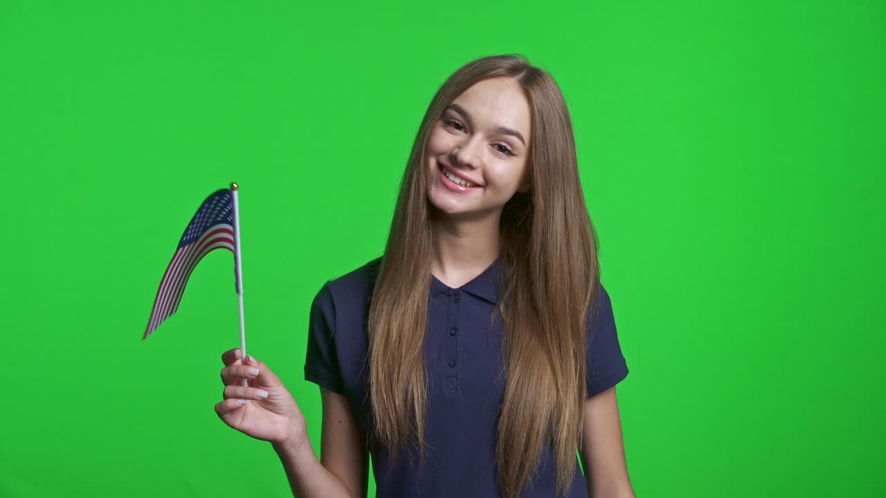 mujer feliz sosteniendo la bandera de ee.uu. y gestando el pulgar hacia arriba
