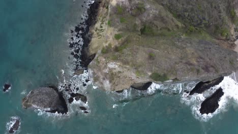over limestone cliff pebble stones at pacific ocean, ecuador coastline