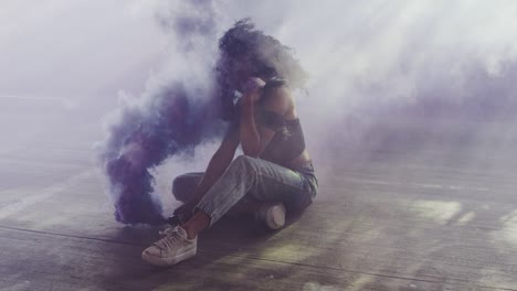 beautiful young woman modeling with purple smoke grenade in dramatic moody lighting