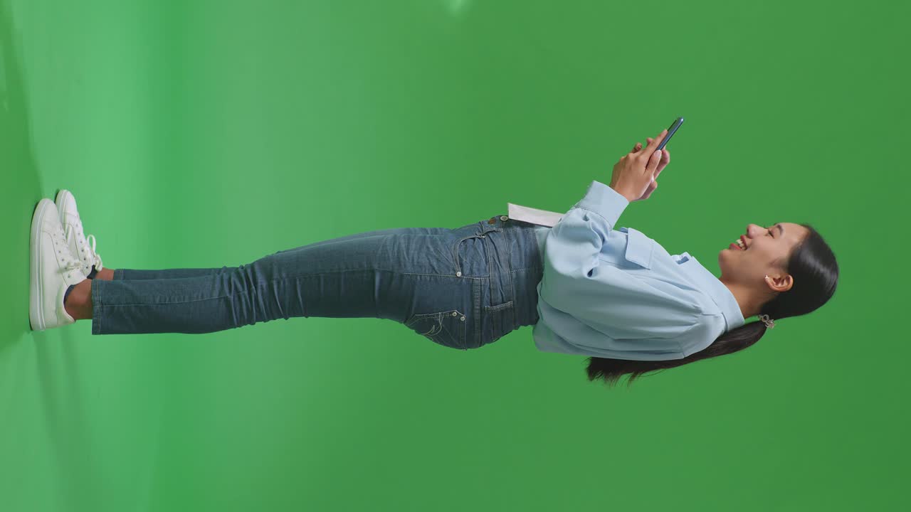 녹색 화면에서 스마트폰을 사용하는 여성