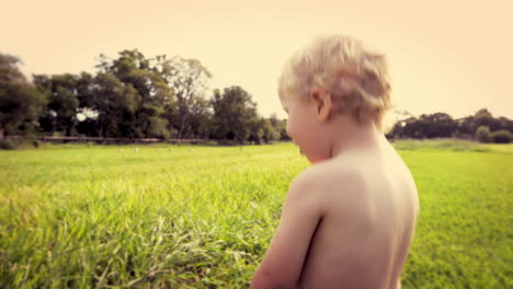 cute baby boy running in grass field