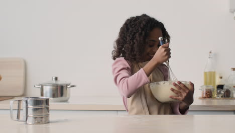 una chica joven horneando en la cocina.