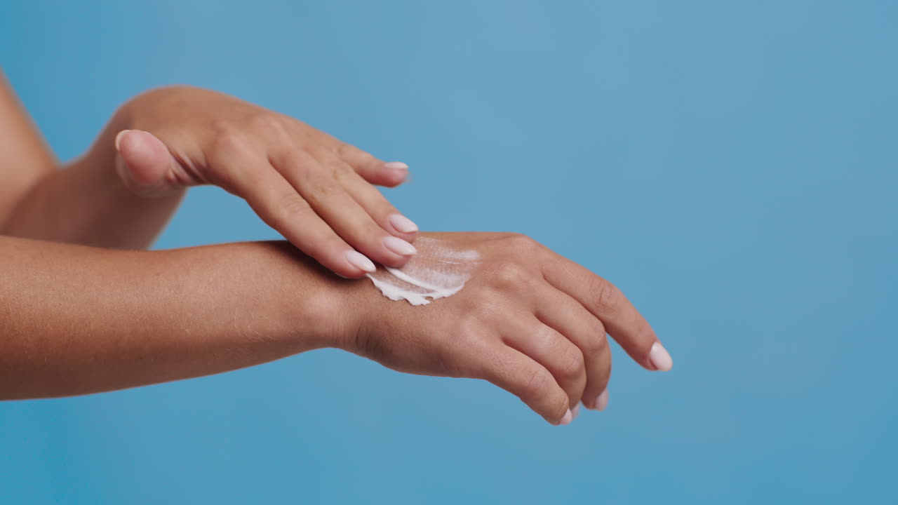 mulher a aplicar loção nas mãos