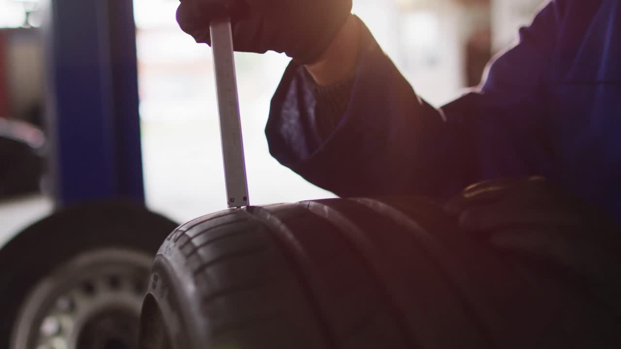 mecánica reparando el neumático del coche en una estación de servicio de coches