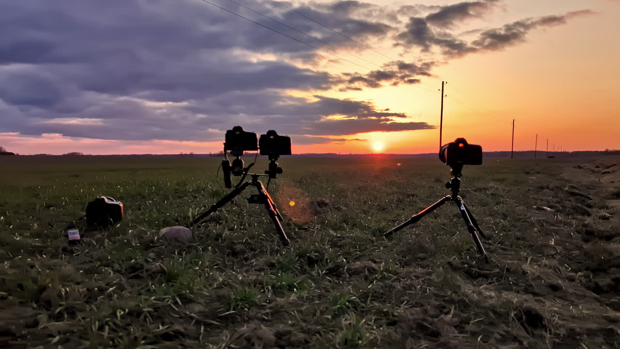 câmeras configuradas para filmar timelapse pôr do sol nascer do sol campo aberto atrás da cena