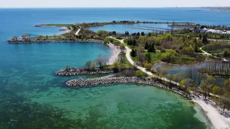 Flying-over-Lake-Ontario-lakeshore-near-Toronto-with-boats-and-a-harbor-in-the-background