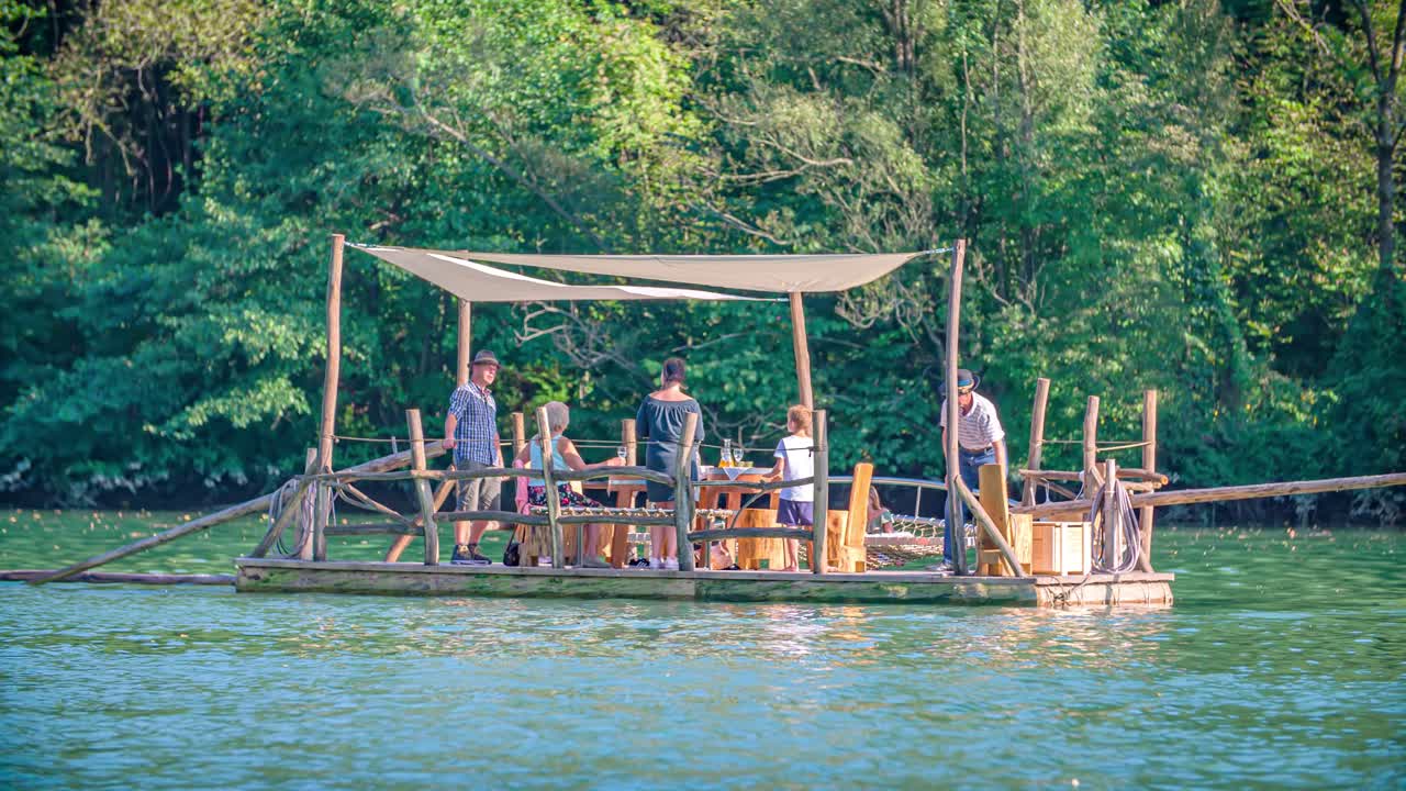 Generational family floats on Hlodovc log-raft on Drava river, Muta, Slovenia