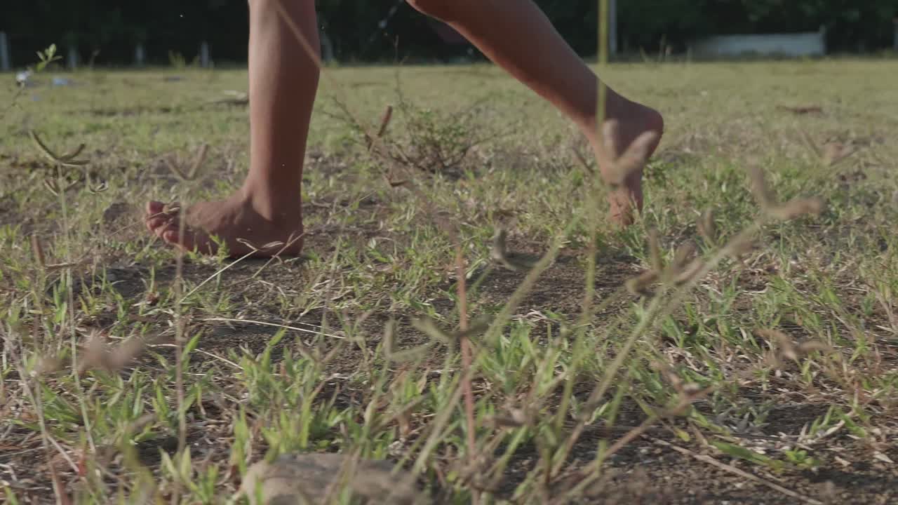Child walking barefoot in a field