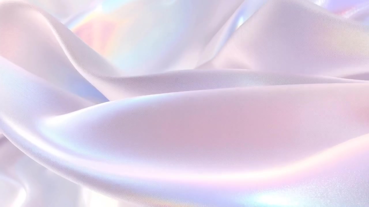 La telecamera si muove lentamente, rivelando in un primo piano in studio un tessuto di raso iridescente per mostrare i riflessi perlati.