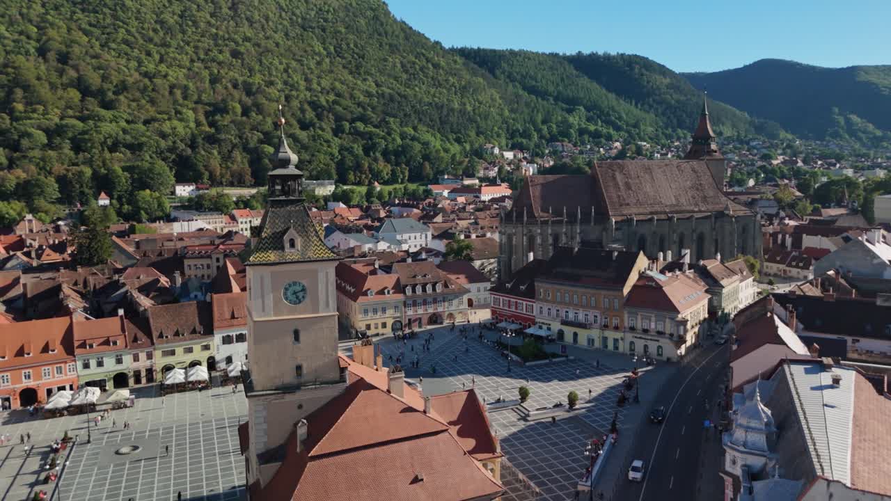 Aerial view of Brasov, Romania; historic square, mountains, sunny day