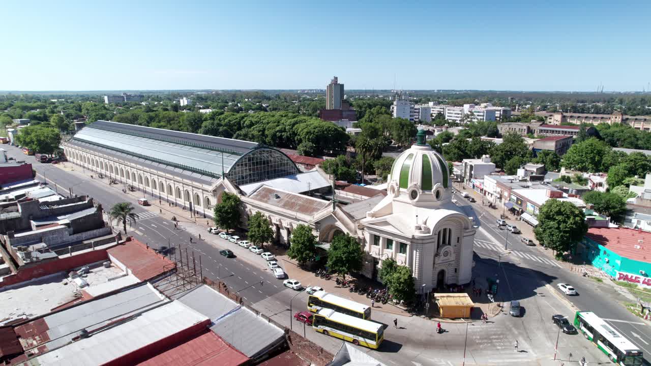 Aerial view of a historic building with a green dome and glass structure in an urban setting