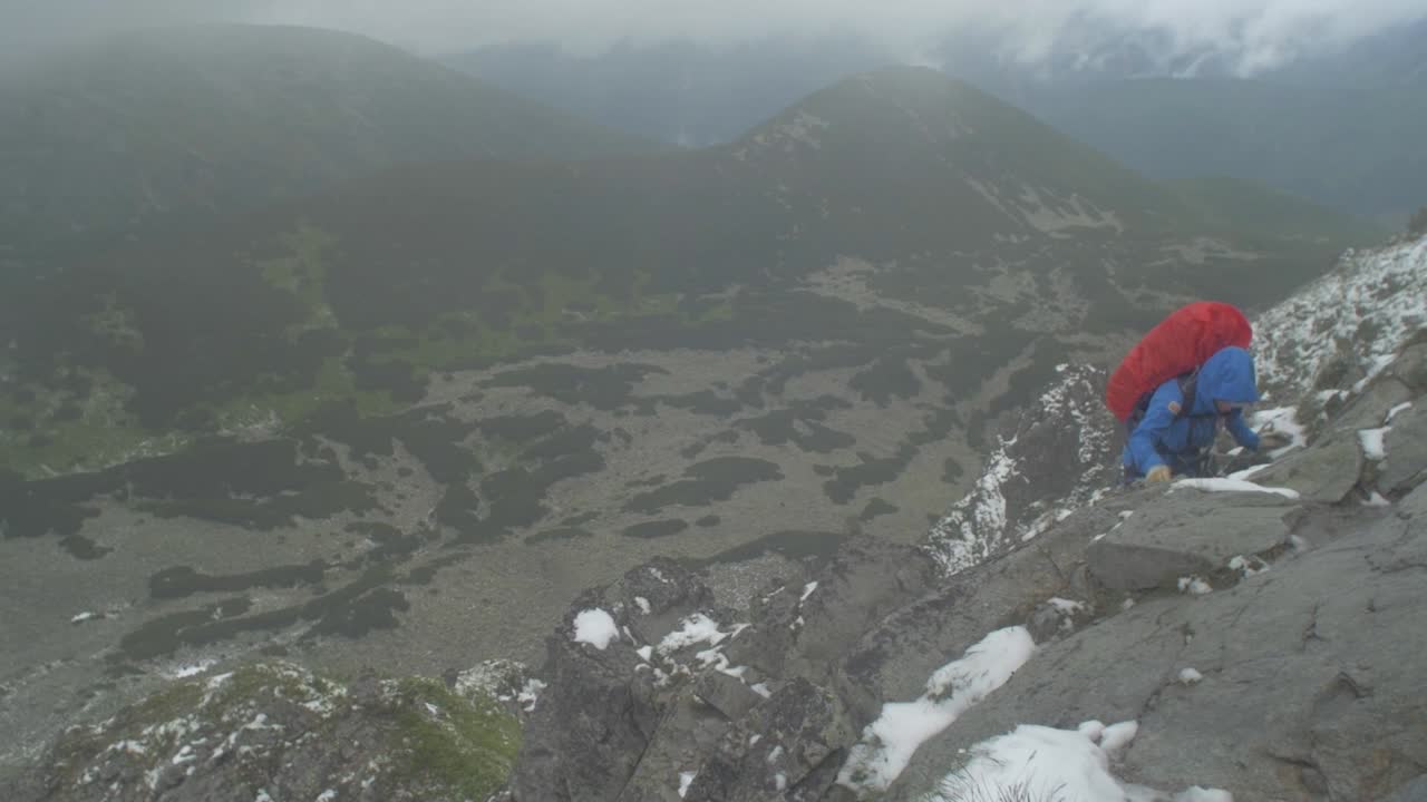 바위가 많은 고산 봉우리, 슬로바키아 타트라 산맥의 풍경, 바위 봉우리를 오르는 여성 등산객의 핸드헬드 샷