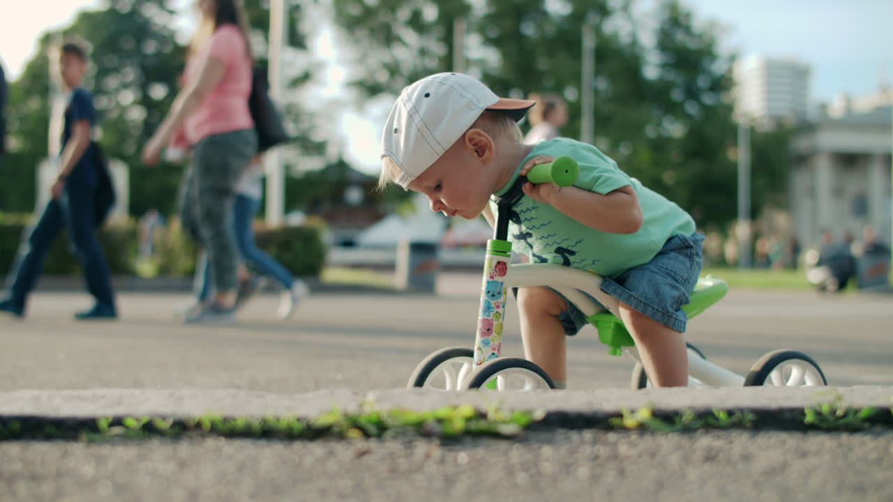 ragazzo concentrato che guida il suo triciclo all'aperto