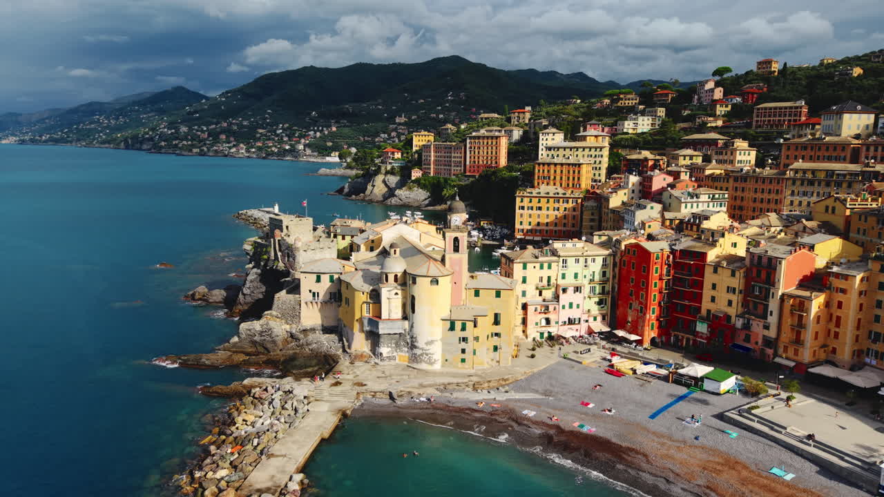 Drone si allontana dalla chiesa di Santa Maria Assunta lungo la costa di Camogli