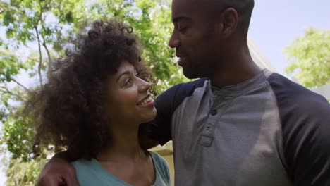 feliz pareja de raza mixta disfrutando en el jardín durante un día soleado