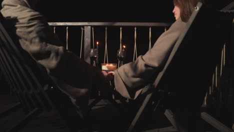 romantic couple enjoying a candlelit dinner on a balcony at night