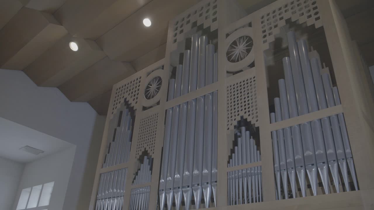 Camera panning along a large wooden organ in a church