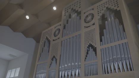 camera panning along a large wooden organ in a church