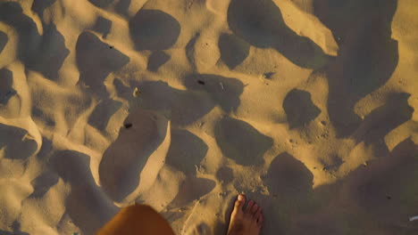 Toma-En-Cámara-Lenta-De-Los-Pies-De-Un-Hombre-Caminando-Por-La-Arena-En-Canon-Beach