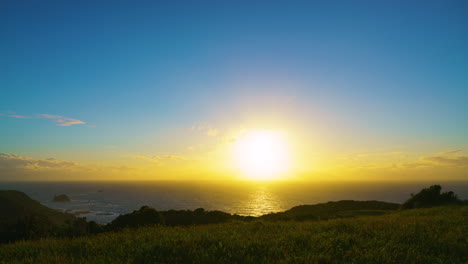 太平洋に沈む太陽のタイムラプス雲がカメラに向かって動き、金色の太陽の光