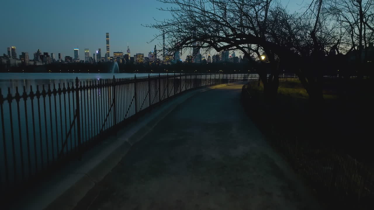 Aerial view of the Jacqueline Kennedy Onassis Reservoir, dusk in Central park, NY, USA - descending, drone shot