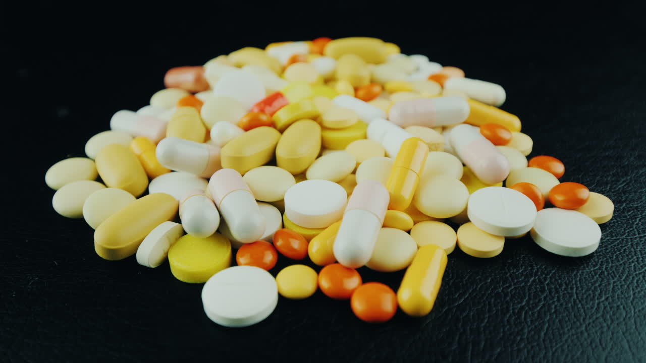 las manos mueven un montón de pastillas y cápsulas