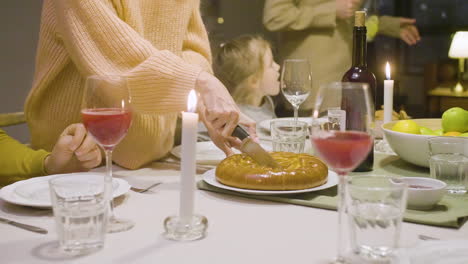 Nahaufnahme-Einer-Frau,-Die-Während-Eines-Abendessens-Mit-Ihrer-Familie-Kuchen-Schneidet