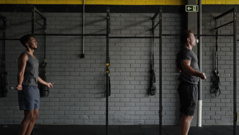 dos hombres saltando la cuerda en un gimnasio