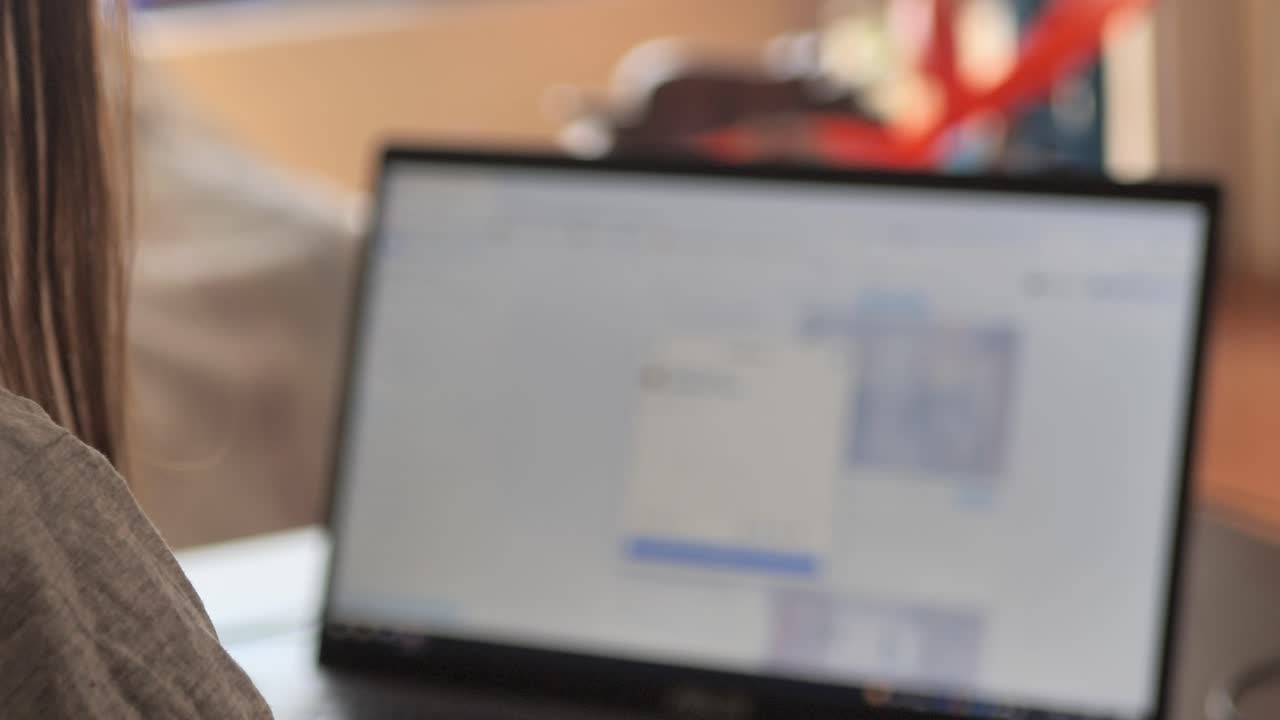 jovencita sentada en el sofá de casa, usando una laptop, viendo videos en línea, leyendo blogs, usando las redes sociales