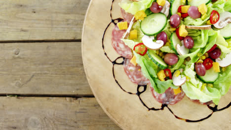carne y ensalada en un plato de madera