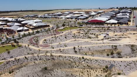 wide aerial orbit over aduro park mountain bike park with new home construction in background