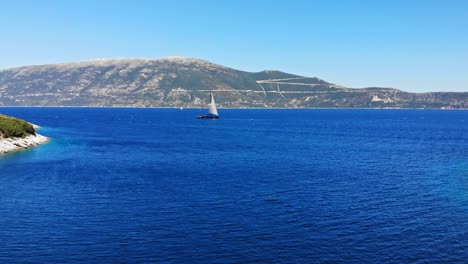 scenic view at agia sofia beach with boat sailing on the blue ocean - aerial drone shot