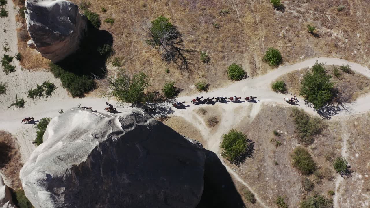 vista aérea de jinetes con caballos caminando por el paisaje de toba del sitio del patrimonio mundial de la unesco goreme, capadocia, anatolia central, turquía, asia