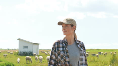 joven agricultora caucásica con sombrero caminando en campo verde y sonriendo