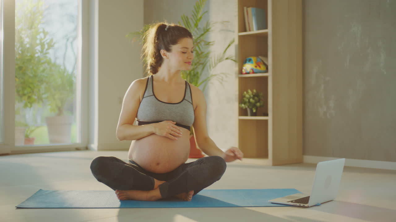 Pregnant woman doing yoga online