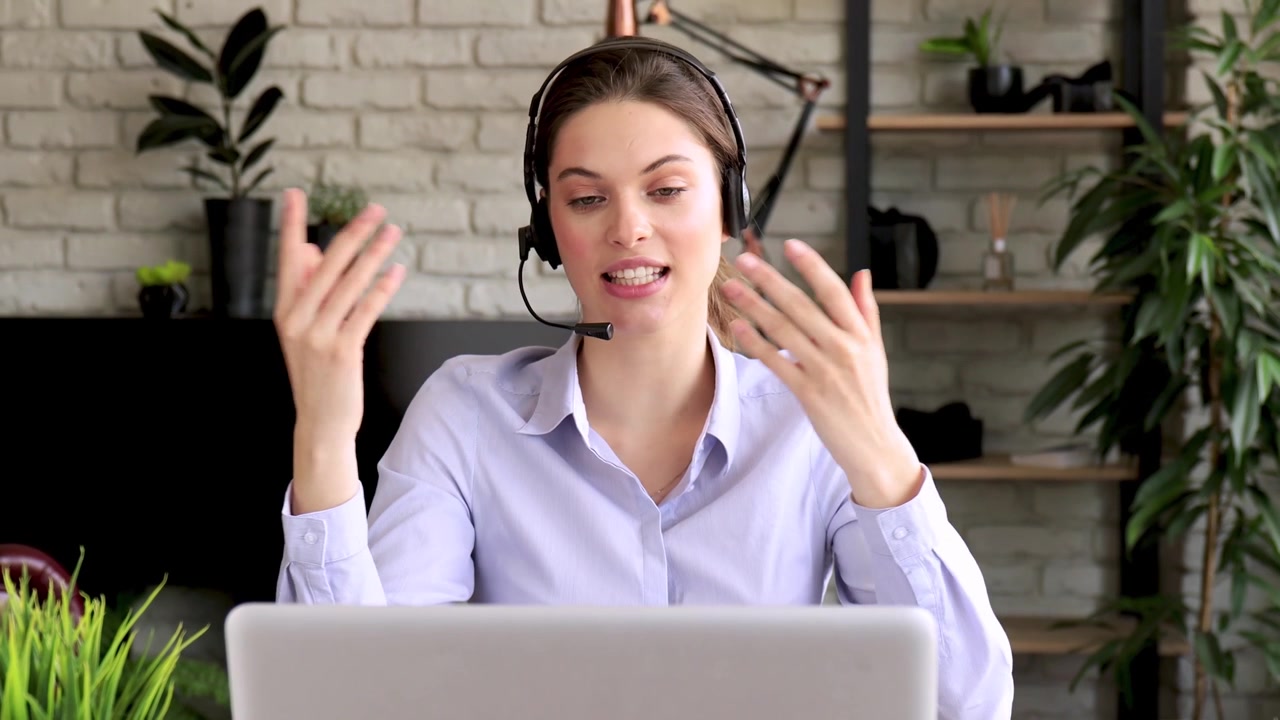Giovane donna con cuffie che parla durante una videochiamata online
