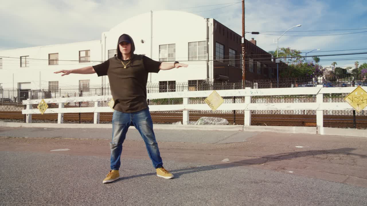 Uomo che balla hip hop per strada in una giornata di sole
