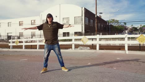 man hip hop dancing outside in street on sunny day