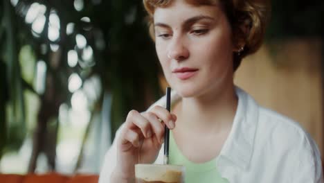 mujer disfrutando de un café helado en una cafetería
