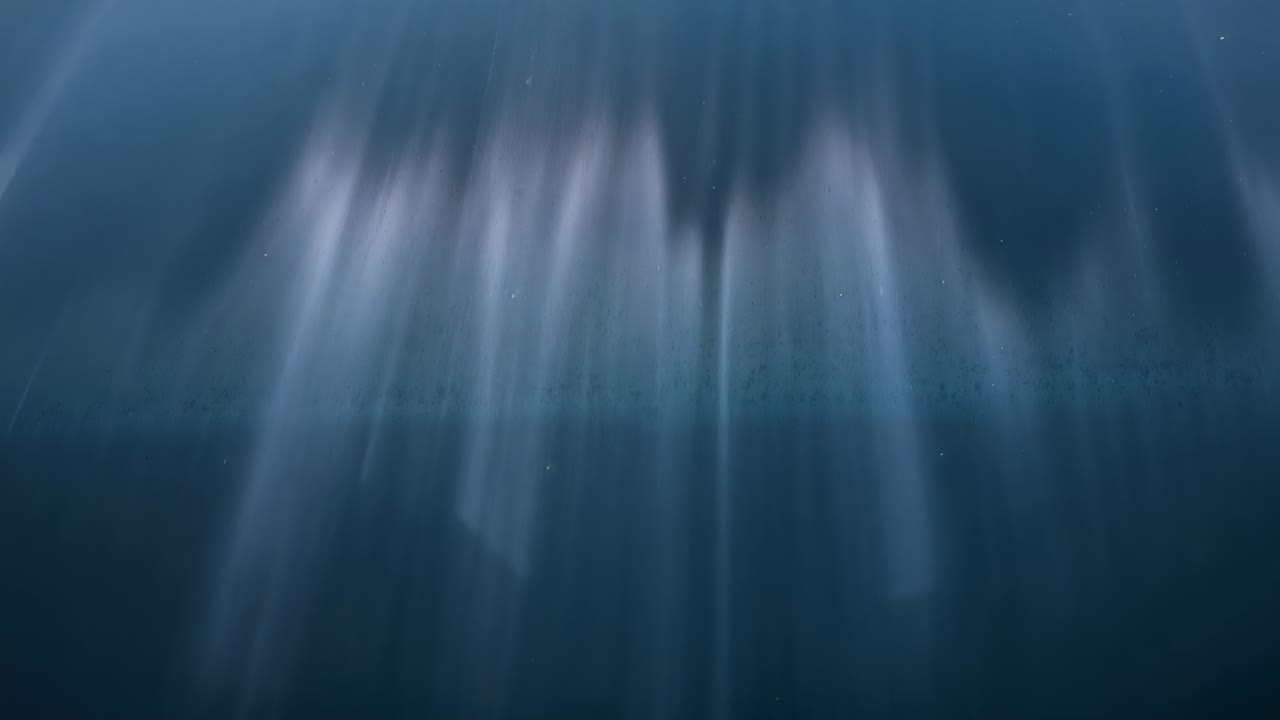 Raggi di luce verticali che brillano dall'alto, illuminandosi e allargandosi in una scena nebbiosa, mostrando forme deboli.