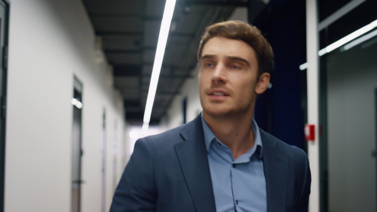 empregado feliz caminhando pelo corredor terminando o dia de trabalho em close-up. homem positivo executivo