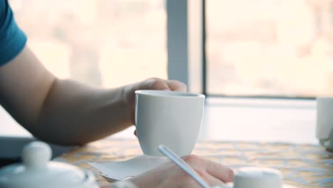 person taking notes in a cafe