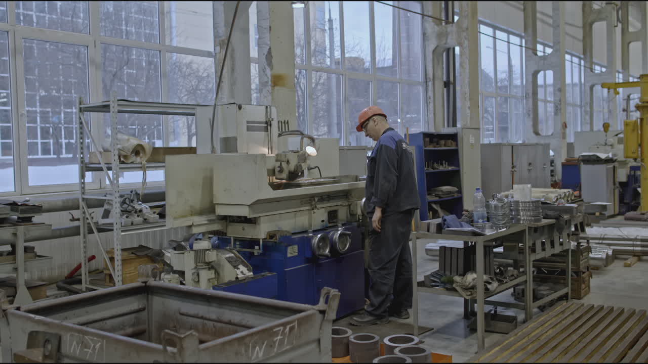 Büyük Bir Endüstriyel Atölyede Taşlama Makinesi Kullanan Fabrika İşçisi