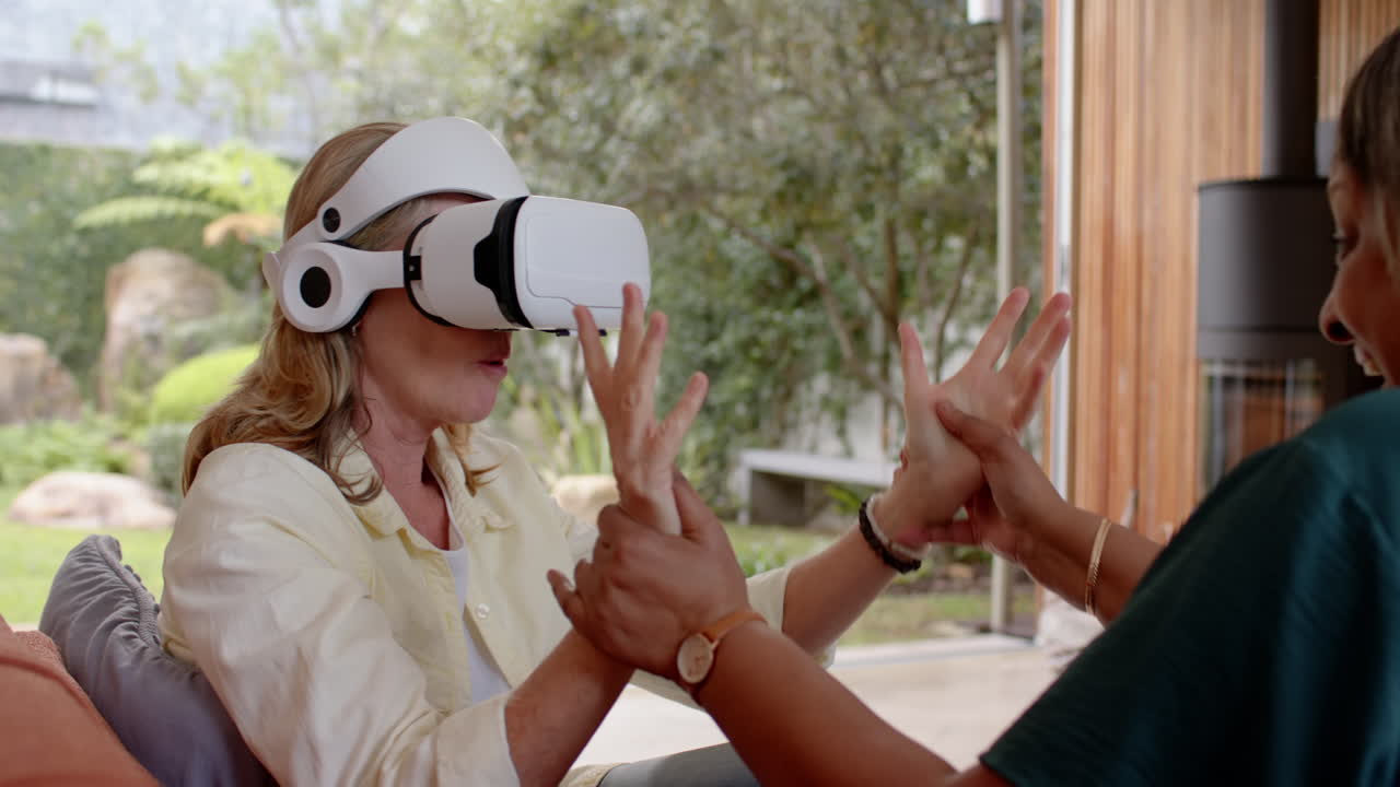Using vr headset, multiracial senior female friends enjoying virtual reality experience, at home